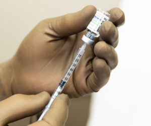 A provider wearing brown gloves prepares an injection for lip filler in Ocala.