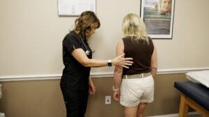 A provider helps a patient onto the scale during an appointment for medical weight loss in Ocala.